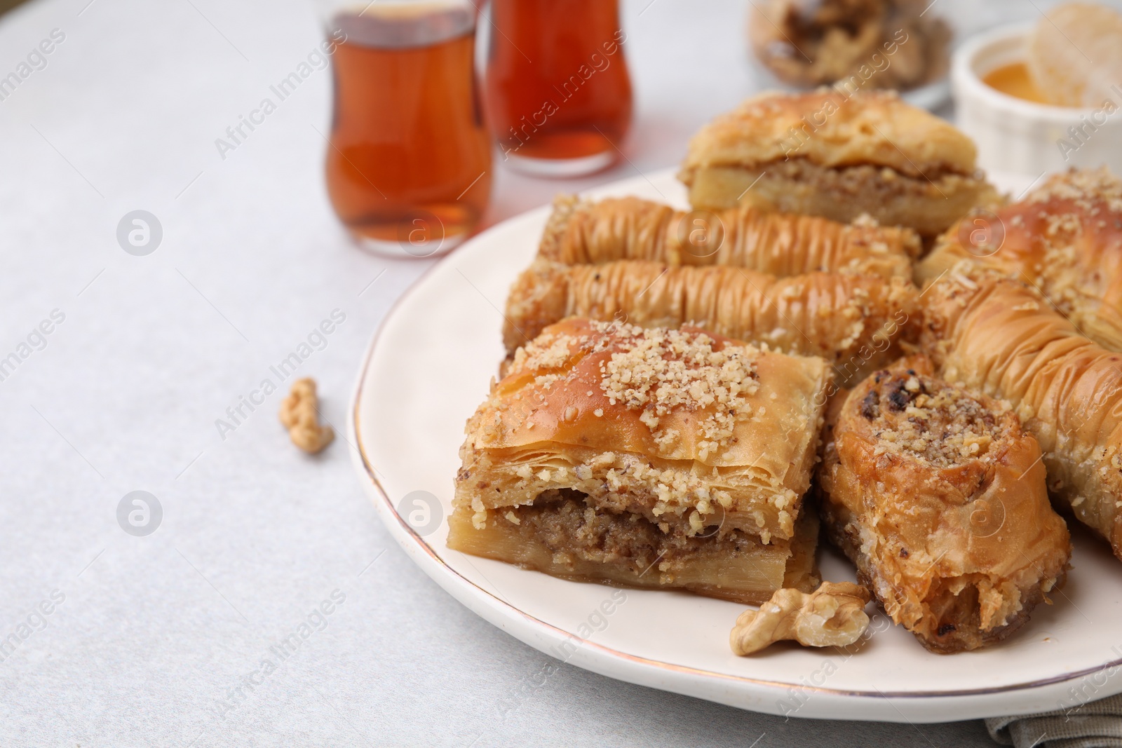 Photo of Eastern sweets. Pieces of tasty baklava on white table, closeup. Space for text