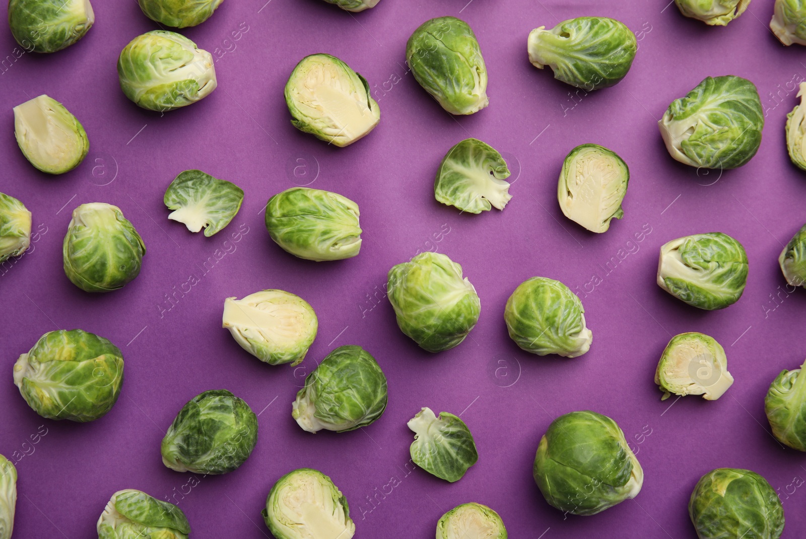 Photo of Fresh Brussels sprouts on purple background, flat lay