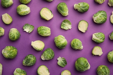 Fresh Brussels sprouts on purple background, flat lay