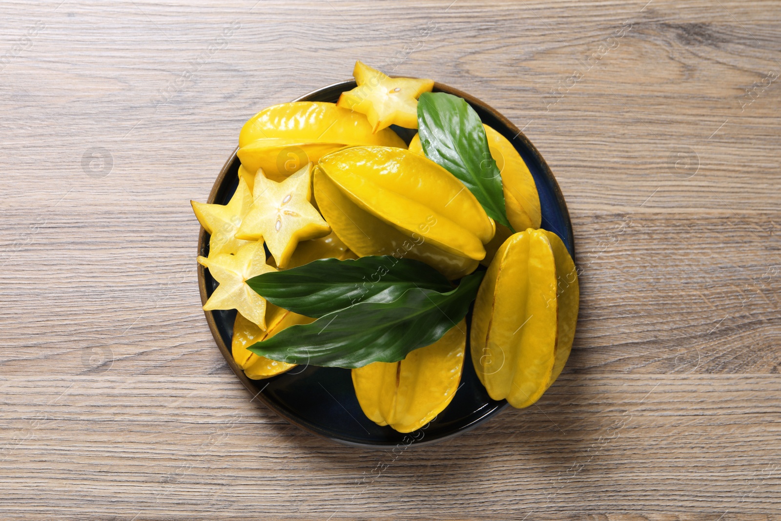 Photo of Delicious carambola fruits on wooden table, top view