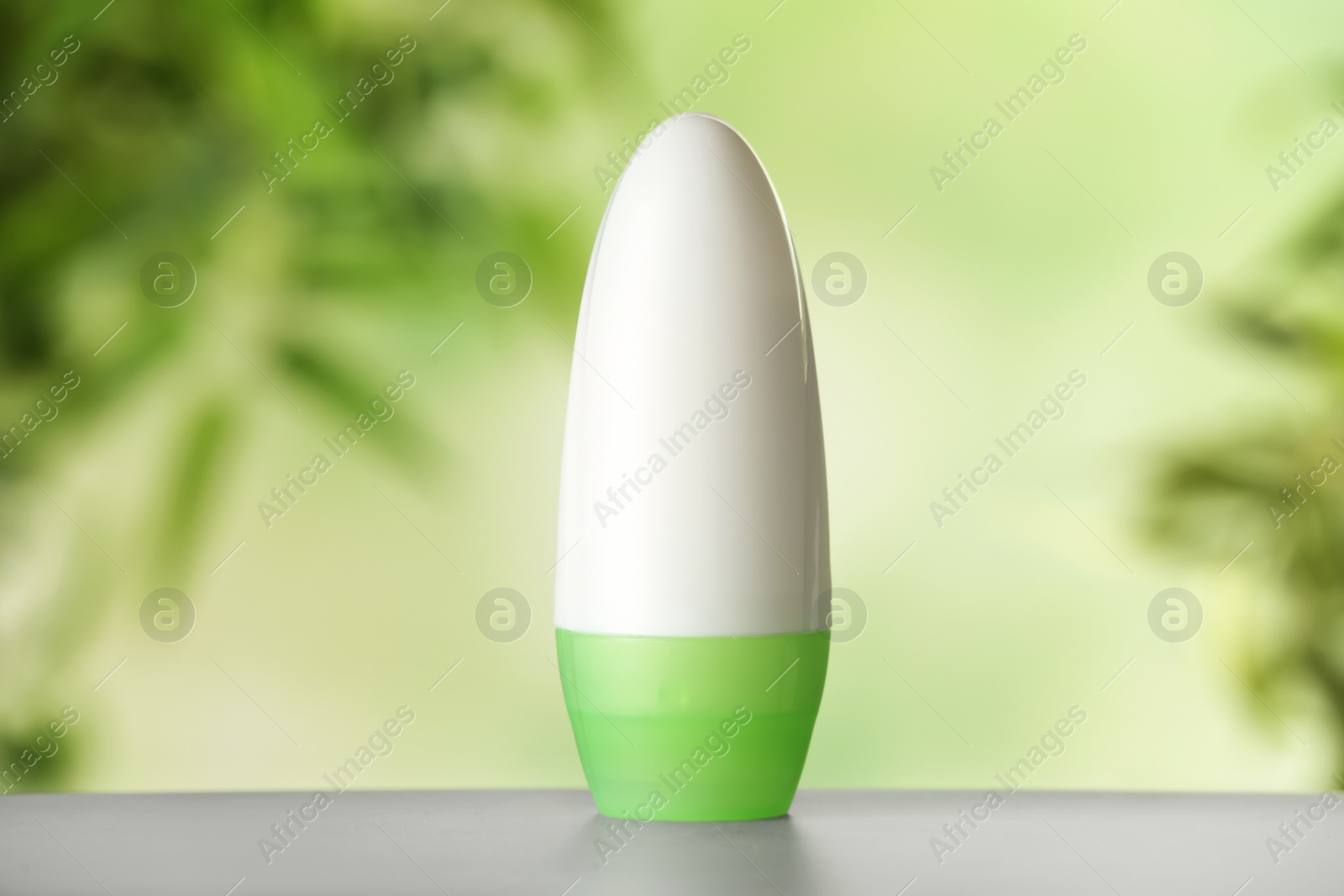 Photo of Deodorant container on white wooden table against blurred background