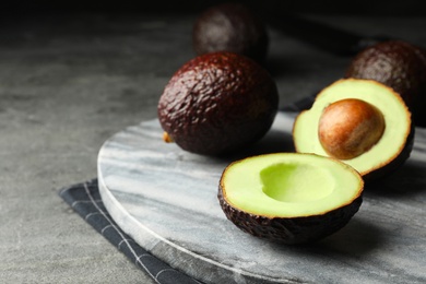 Delicious fresh ripe avocados on grey table