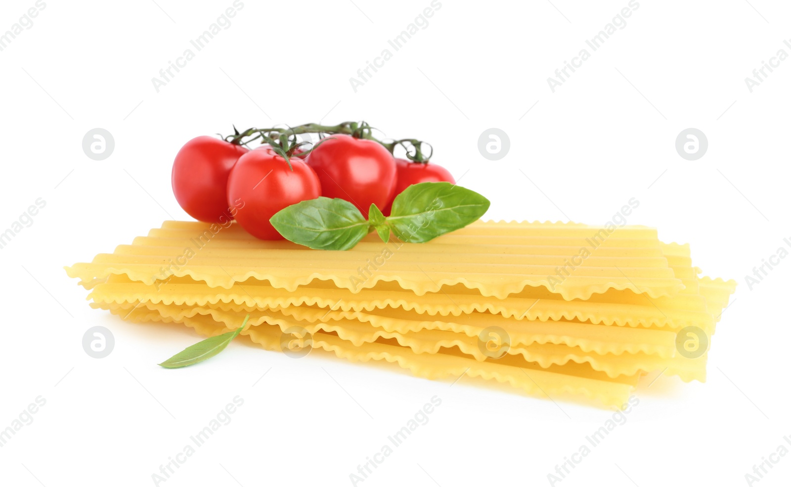 Photo of Uncooked lasagna sheets, cherry tomatoes and basil isolated on white