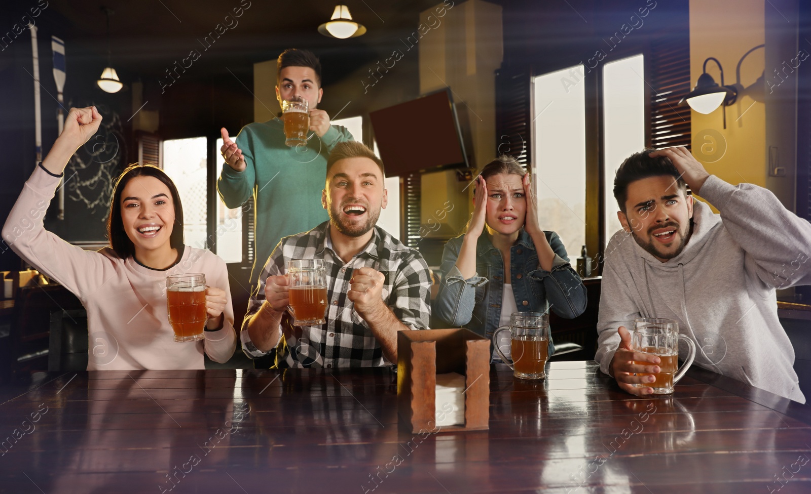 Photo of Group of friends watching football in sport bar