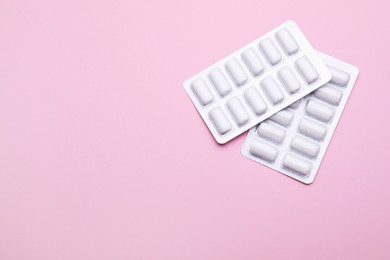Photo of Blisters with chewing gums on pink background, flat lay. Space for text