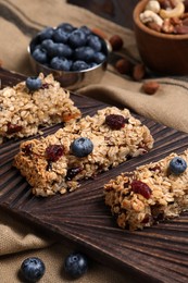Photo of Tasty granola bars with berries on table