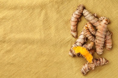Photo of Many raw turmeric roots on table, flat lay. Space for text