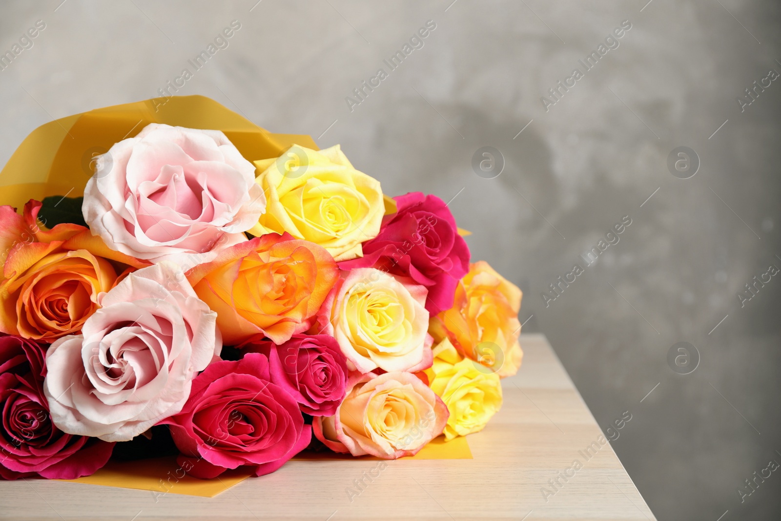 Photo of Luxury bouquet of fresh roses on wooden table, closeup