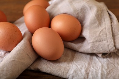 Raw brown chicken eggs on wooden table, closeup