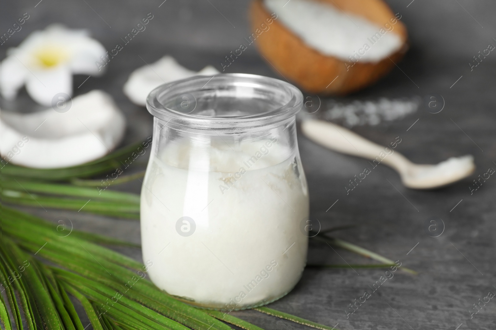 Photo of Glass jar with coconut oil on table. Healthy cooking