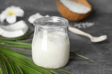 Photo of Glass jar with coconut oil on table. Healthy cooking