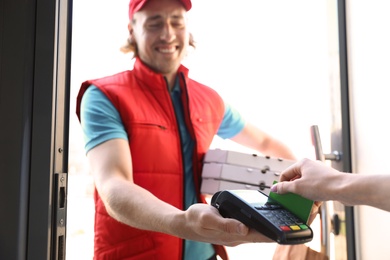 Woman paying for food delivery with credit card at door, closeup