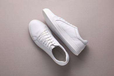 Photo of Pair of stylish white sneakers on grey background, top view