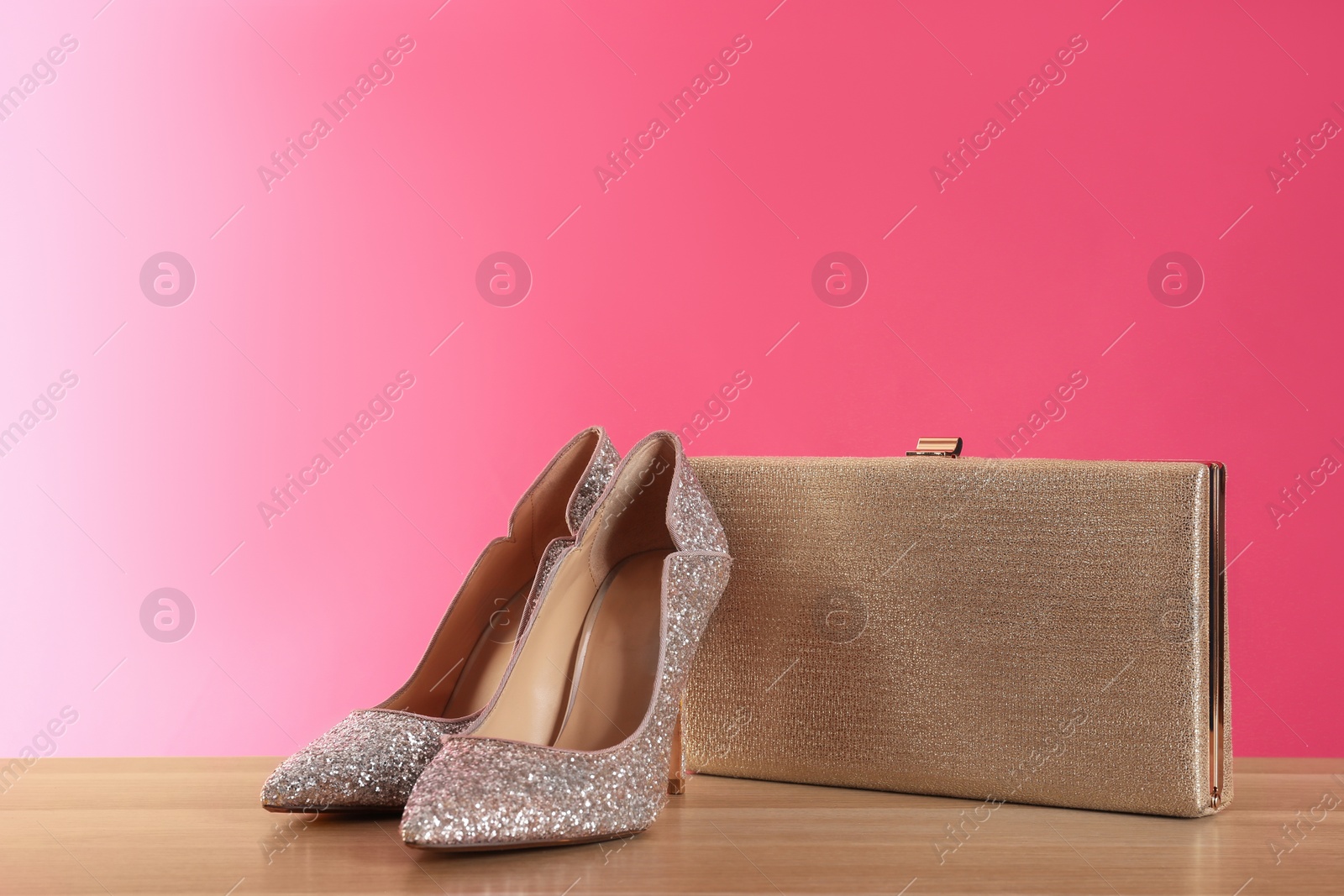 Photo of Stylish woman's purse and shoes on wooden table