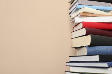 Photo of Stack of hardcover books on beige background. Space for text