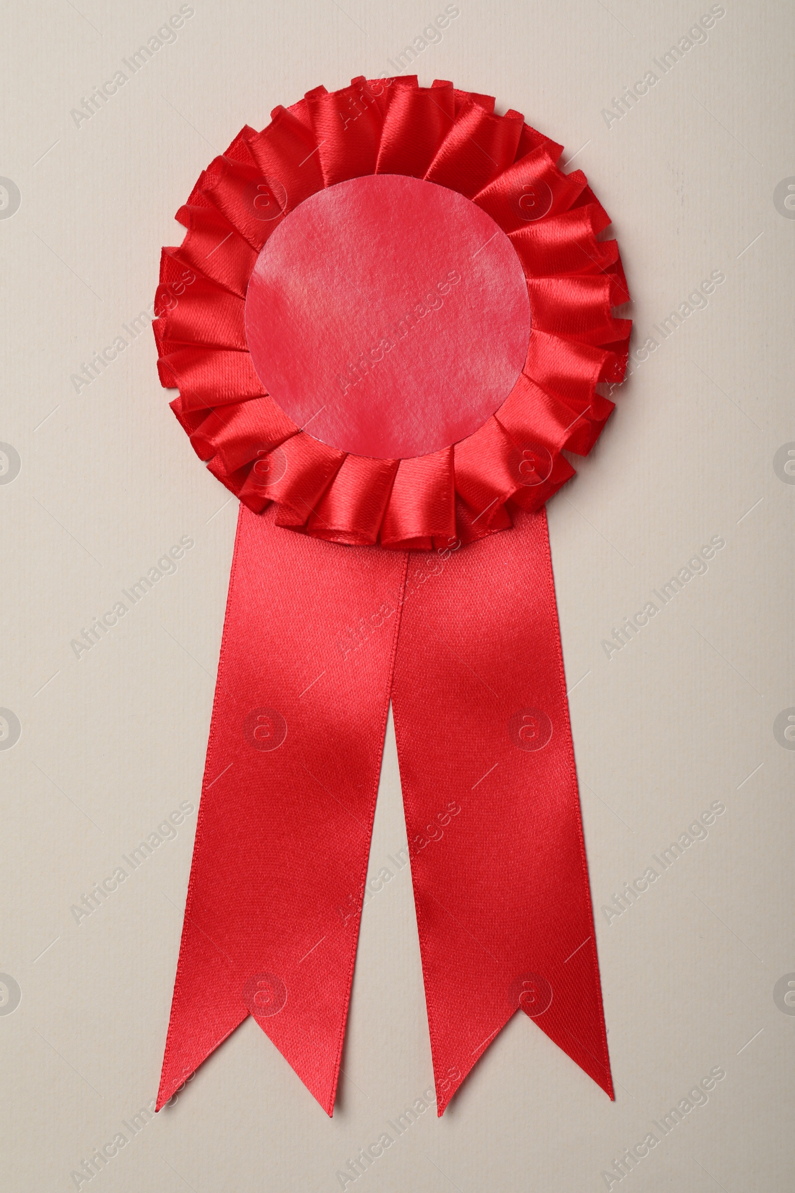 Photo of Red award ribbon on beige background, top view