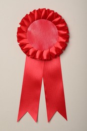 Photo of Red award ribbon on beige background, top view