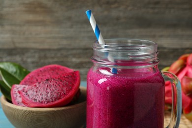Photo of Delicious pitahaya smoothie in mason jar, closeup. Space for text