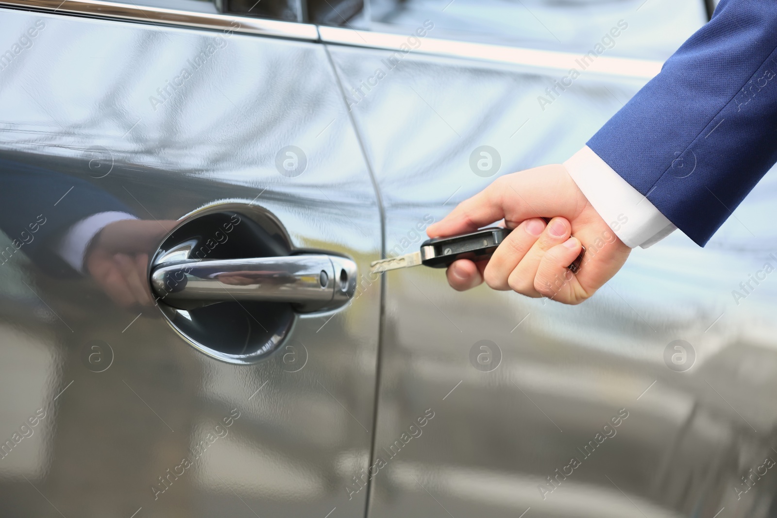 Photo of Closeup view of man opening car door with key