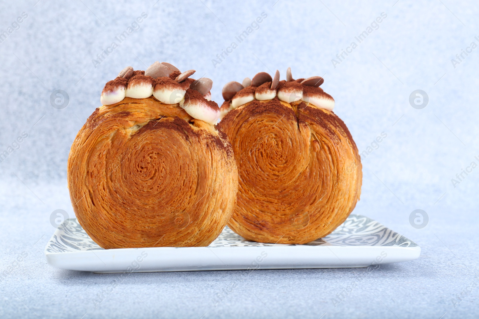 Photo of Supreme croissants with chocolate chips and cream on grey background, closeup. Tasty puff pastry