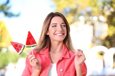 Photo of Young happy woman with sweet candies outdoors