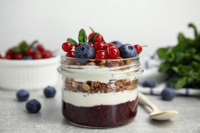 Photo of Delicious yogurt parfait with fresh berries and mint on light grey table