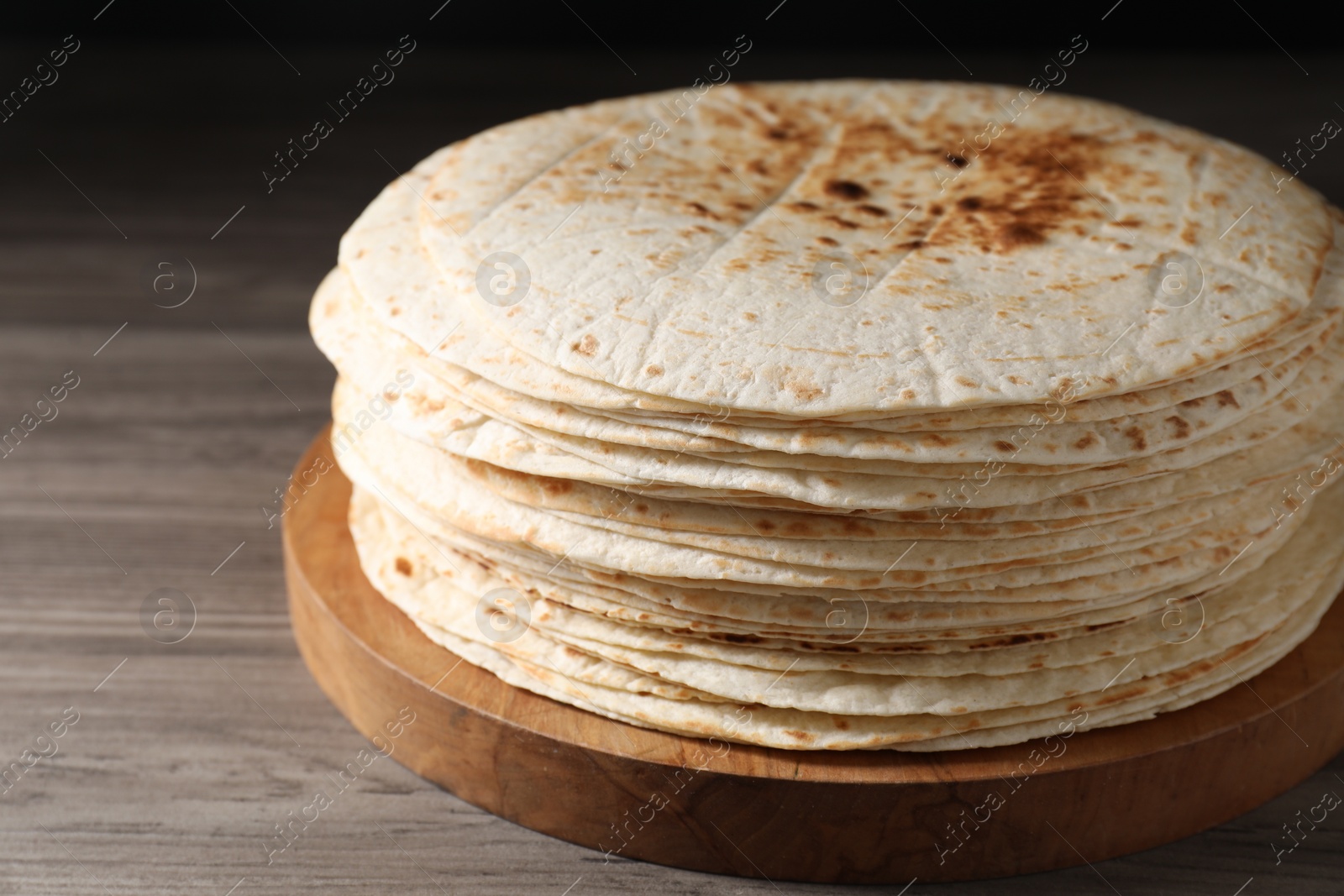 Photo of Many tasty homemade tortillas on wooden table