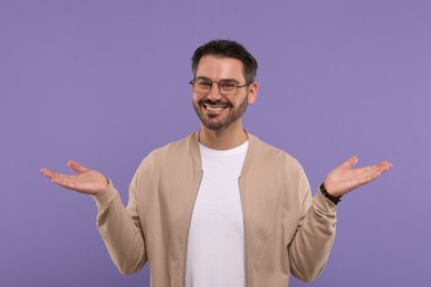 Photo of Portrait of happy man in stylish glasses on violet background