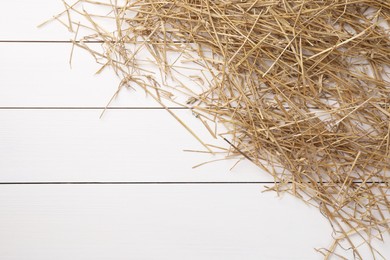 Photo of Dried straw on white wooden table, top view. Space for text