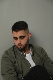 Photo of Portrait of sad man near light grey wall