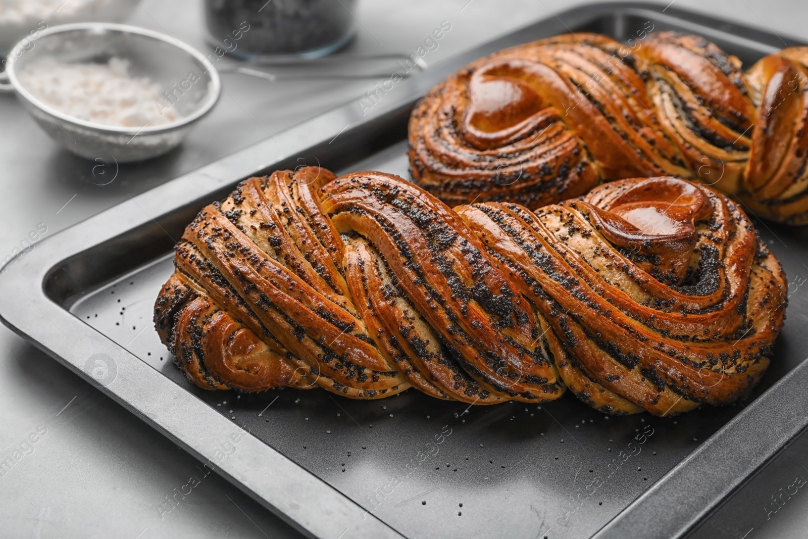 Photo of Tasty sweet buns with poppy seeds on gray table