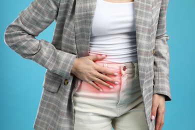 Photo of Woman suffering from appendicitis inflammation on light blue background, closeup