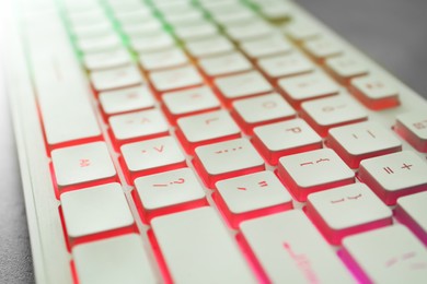 Photo of Modern keyboard with RGB lighting on table, closeup
