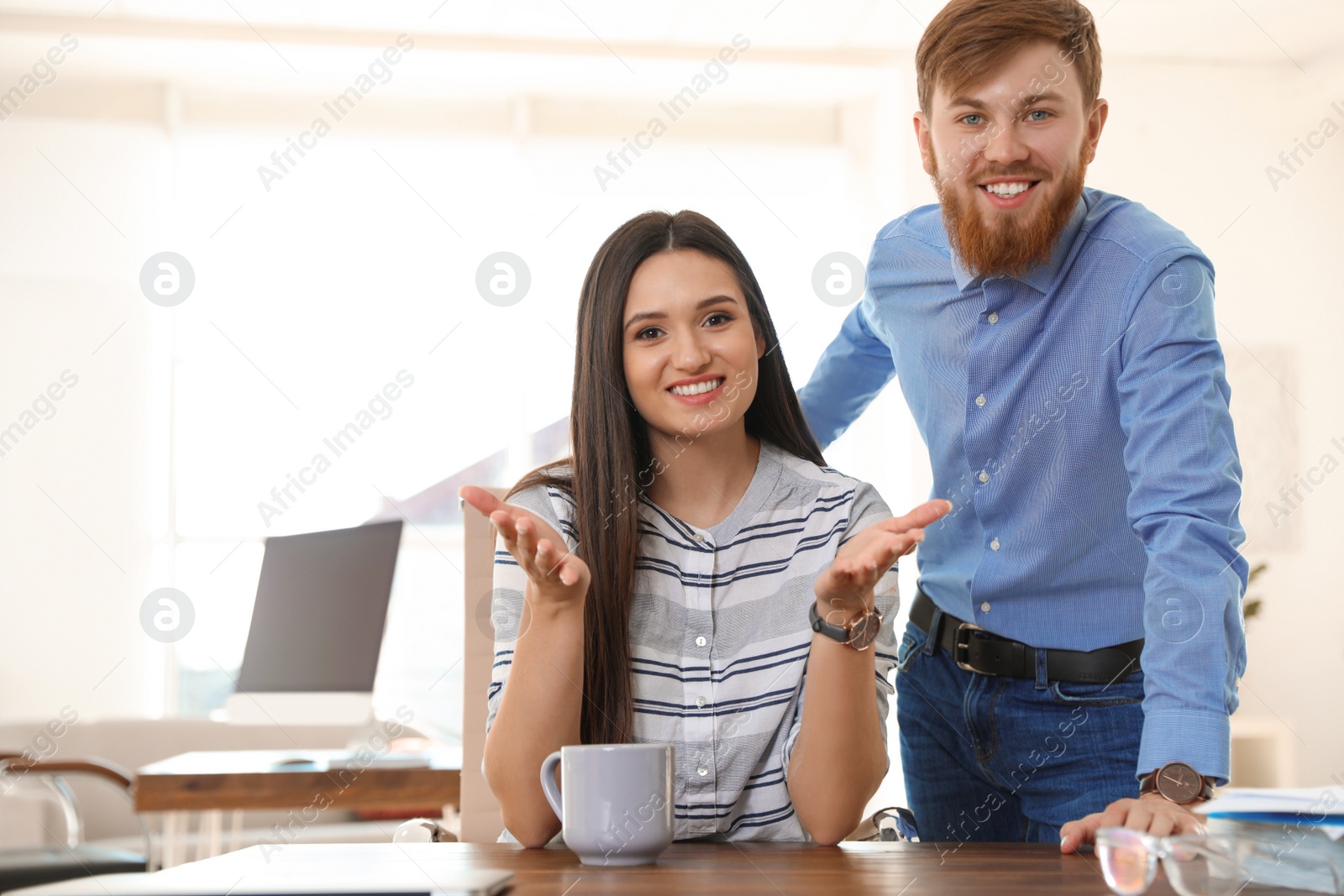 Photo of Happy young couple looking at camera and using video chat in home office. Space for text