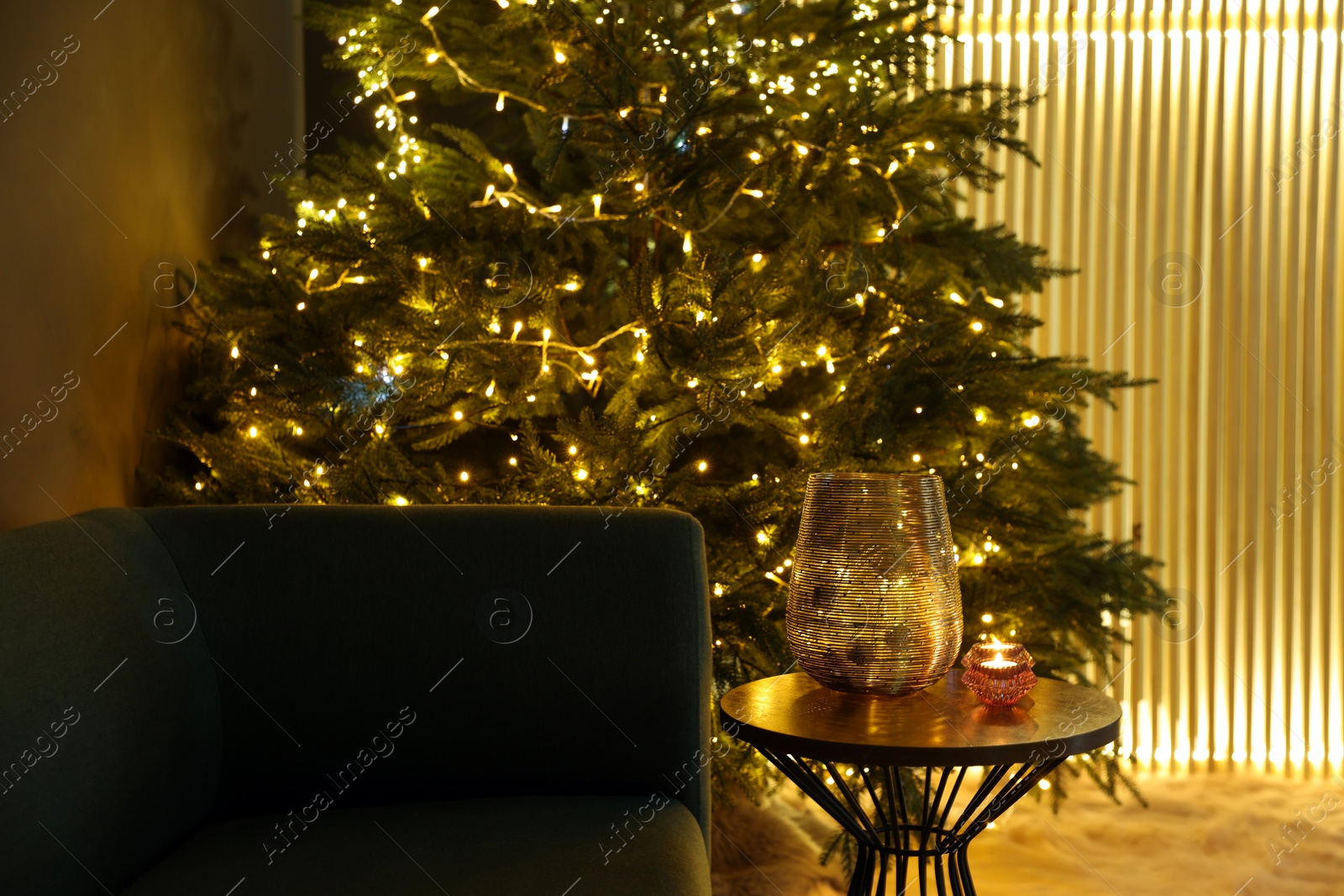 Photo of Vase, scented candles and beautiful Christmas tree in living room