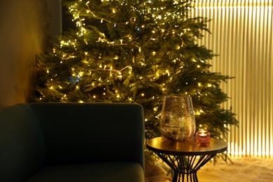 Photo of Vase, scented candles and beautiful Christmas tree in living room