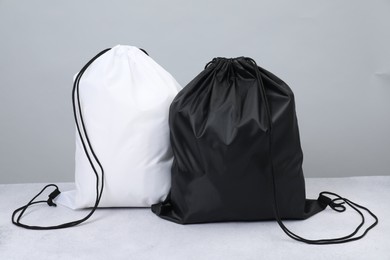 Two drawstring bags on light textured table