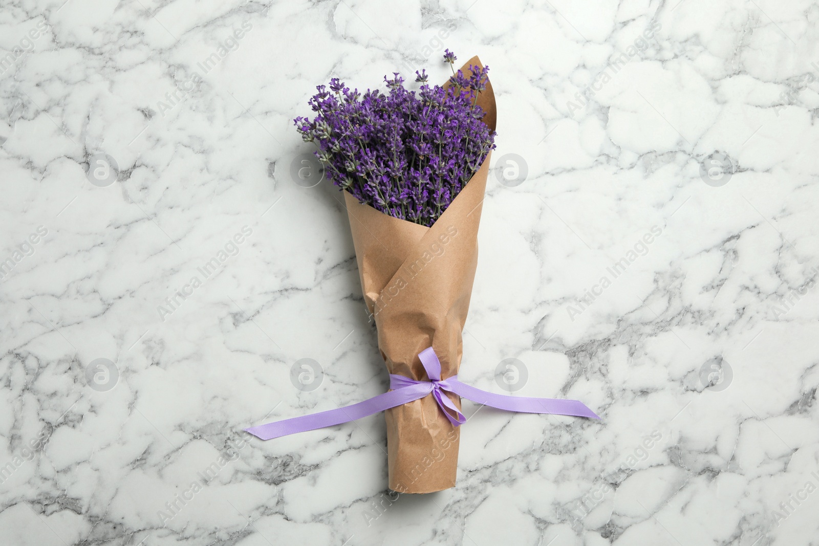 Photo of Beautiful lavender bouquet on white marble background, top view