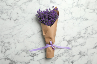 Photo of Beautiful lavender bouquet on white marble background, top view