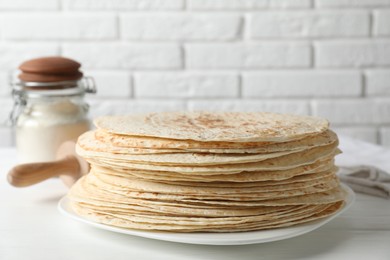 Photo of Stack of tasty homemade tortillas on white wooden table