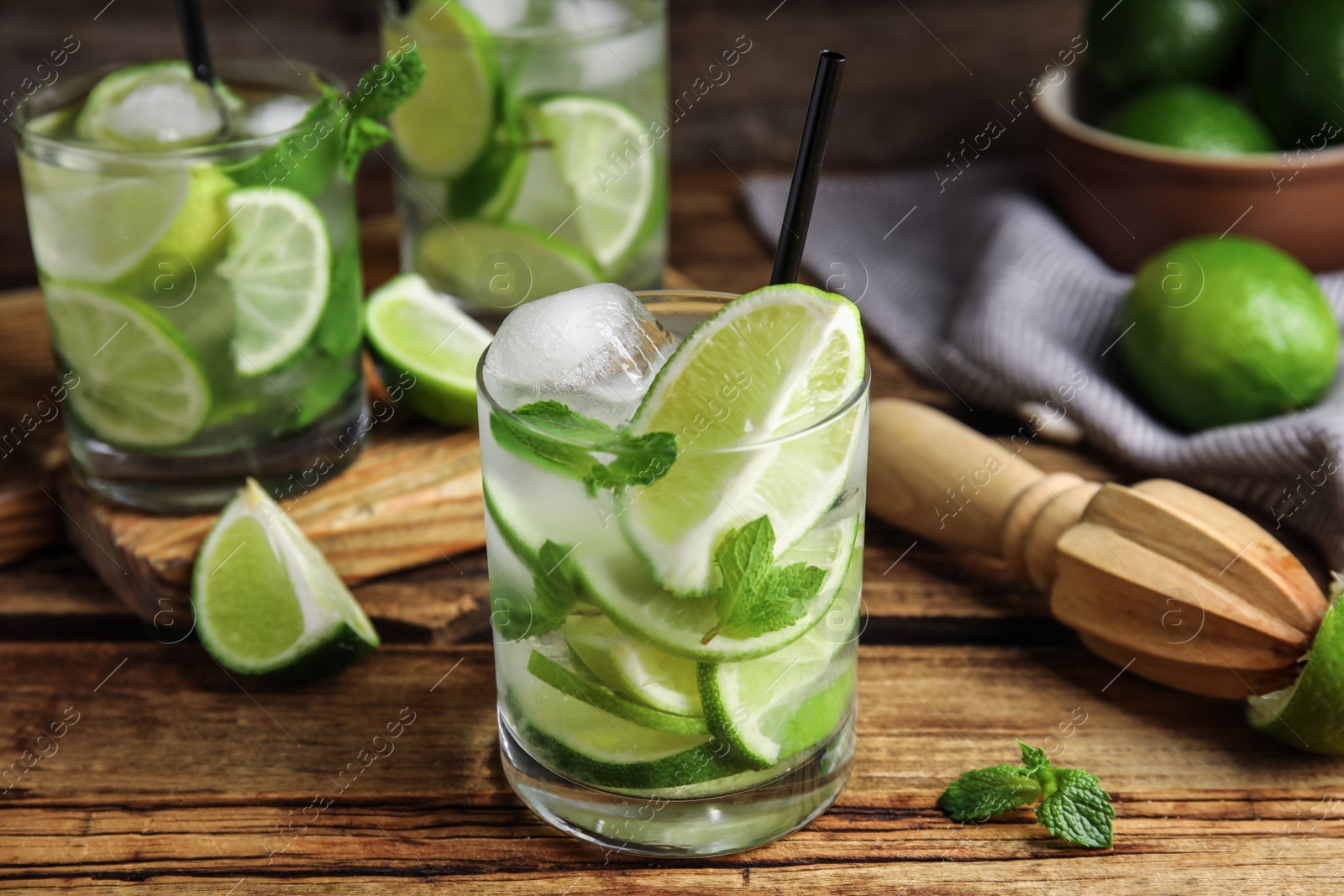 Photo of Delicious mojito and ingredients on wooden table