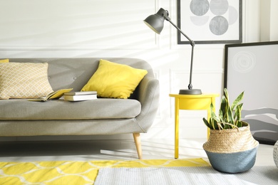 Stylish living room with sofa. Interior design in grey and yellow colors