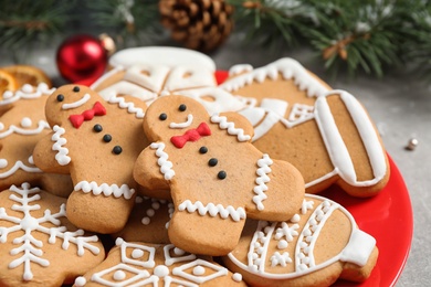 Photo of Tasty homemade Christmas cookies on red plate, closeup view