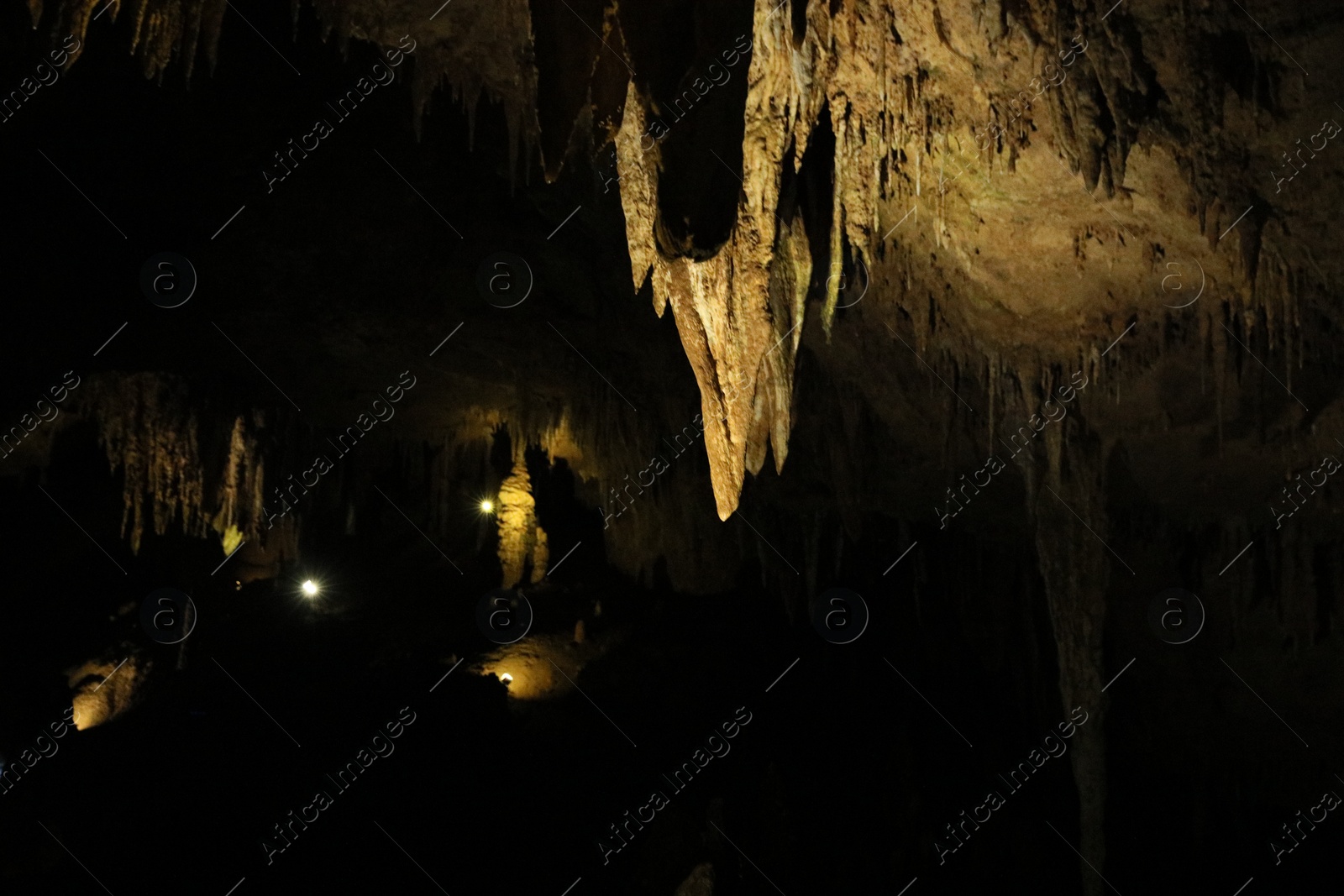 Photo of Picturesque view of many stalactite formations in dark cave