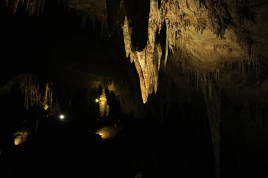 Photo of Picturesque view of many stalactite formations in dark cave