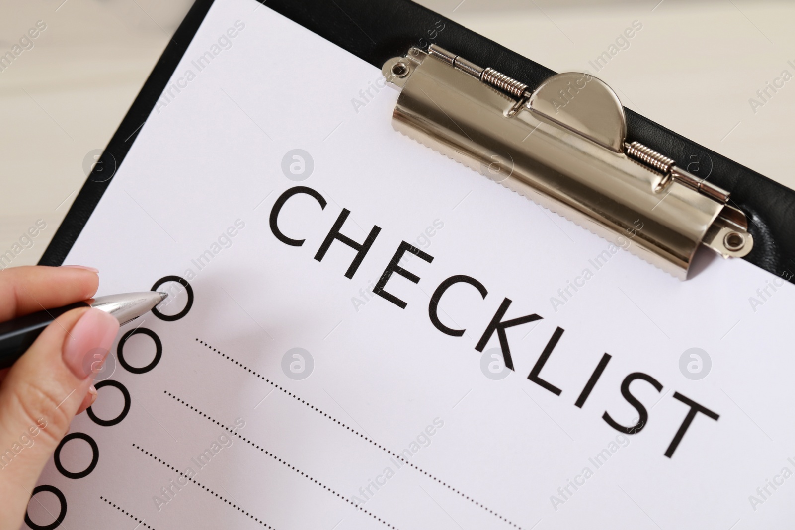 Photo of Woman filling Checklist with pen, closeup view