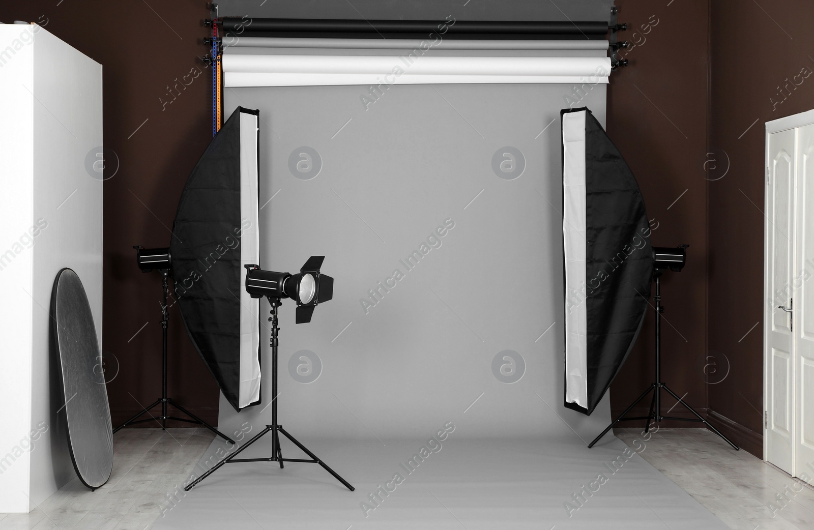 Photo of Grey photo background and professional lighting equipment in studio