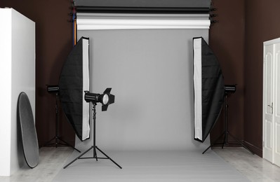 Grey photo background and professional lighting equipment in studio