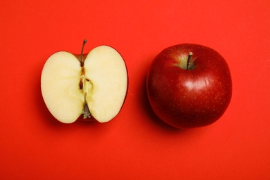 Flat lay composition with ripe juicy apples on red background