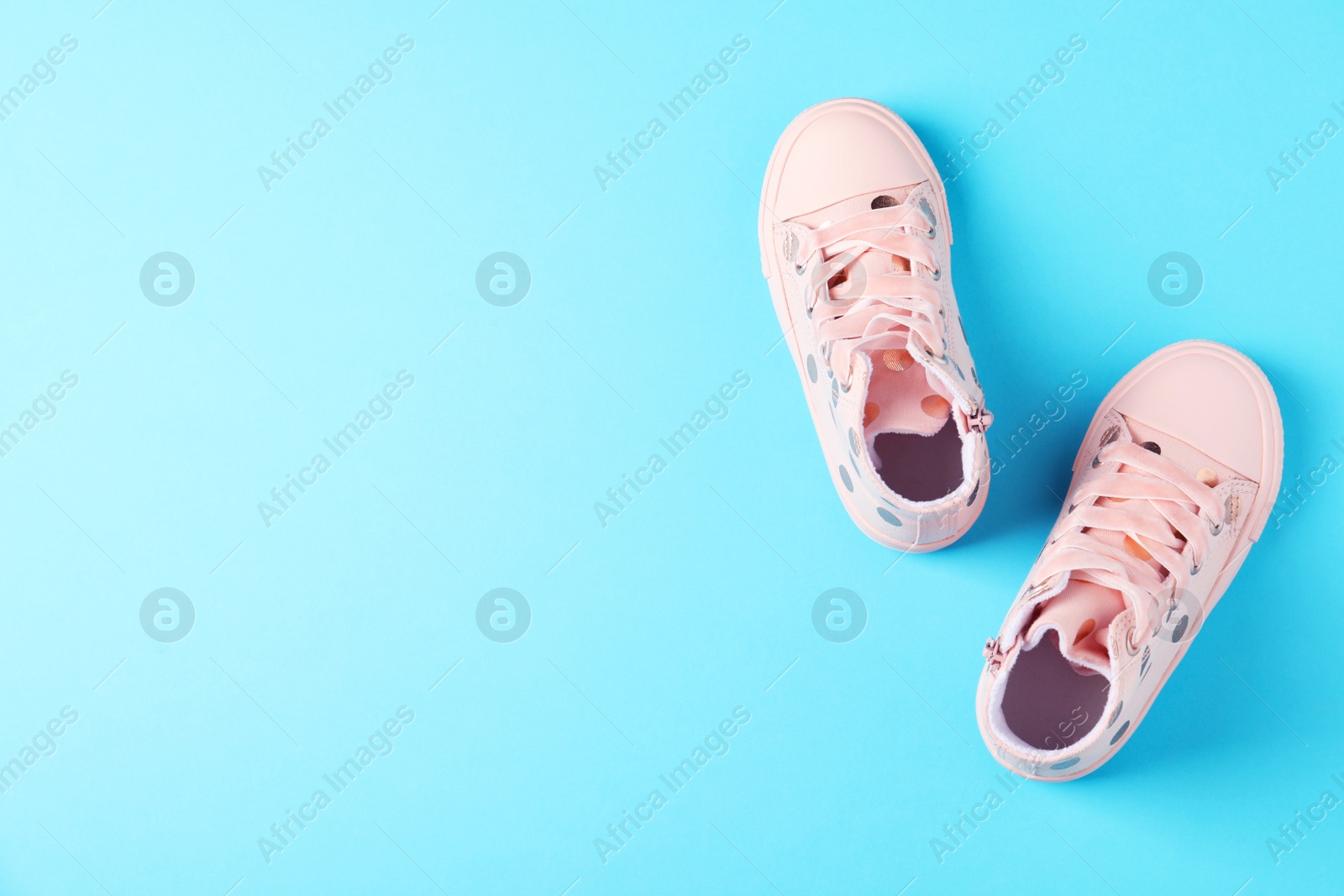 Photo of Pair of stylish child shoes on blue background, flat lay. Space for text